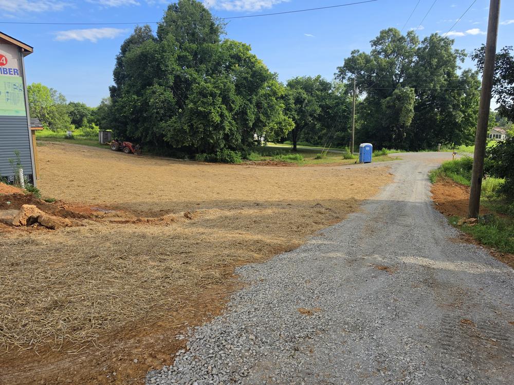 Graded and shaped ground with a new driveway base on a construction site.