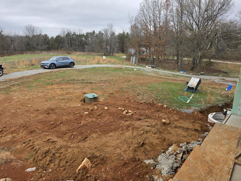 A bare lot roughed in and leveled, with spoil piles at the edges, ready for building.